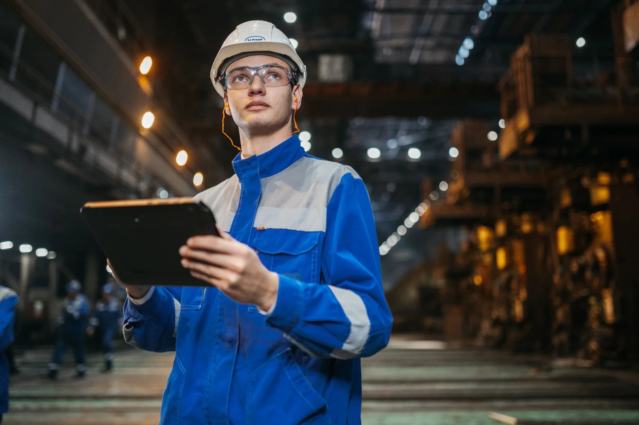 An engineer using a tablet on an industrial production floor