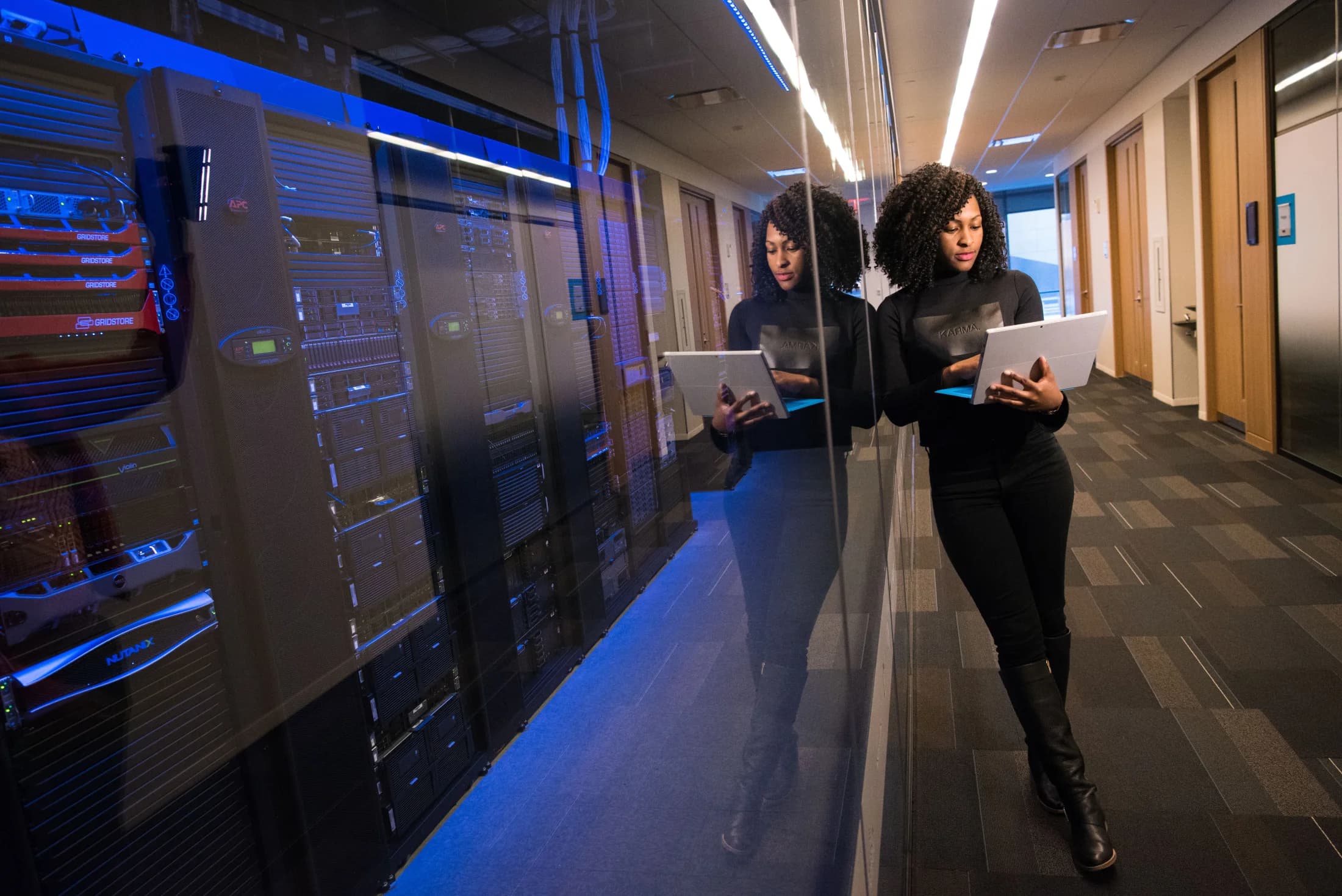 A software engineer working with a laptop inside a data center