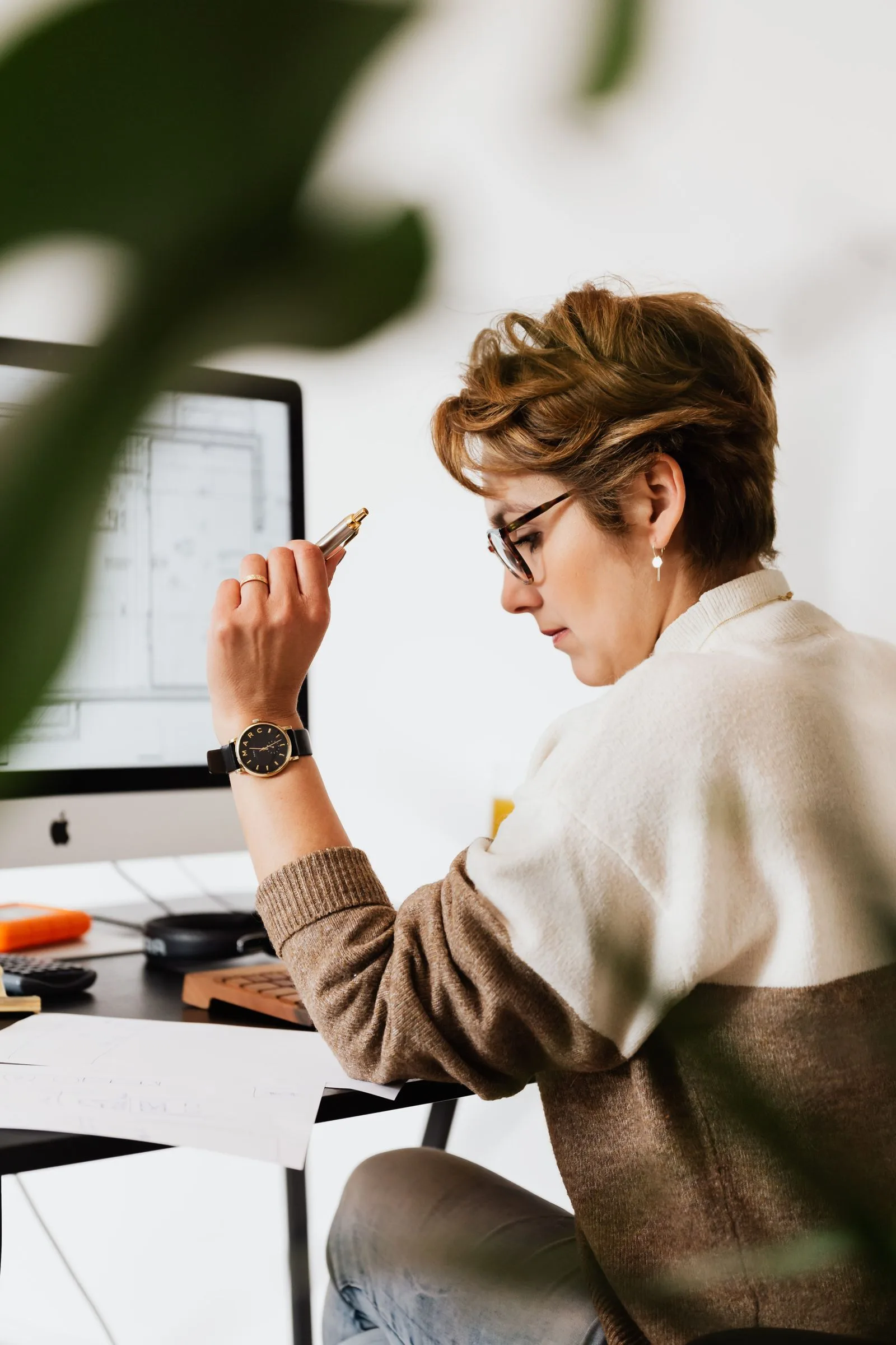 A professional reviewing technical work at a desk