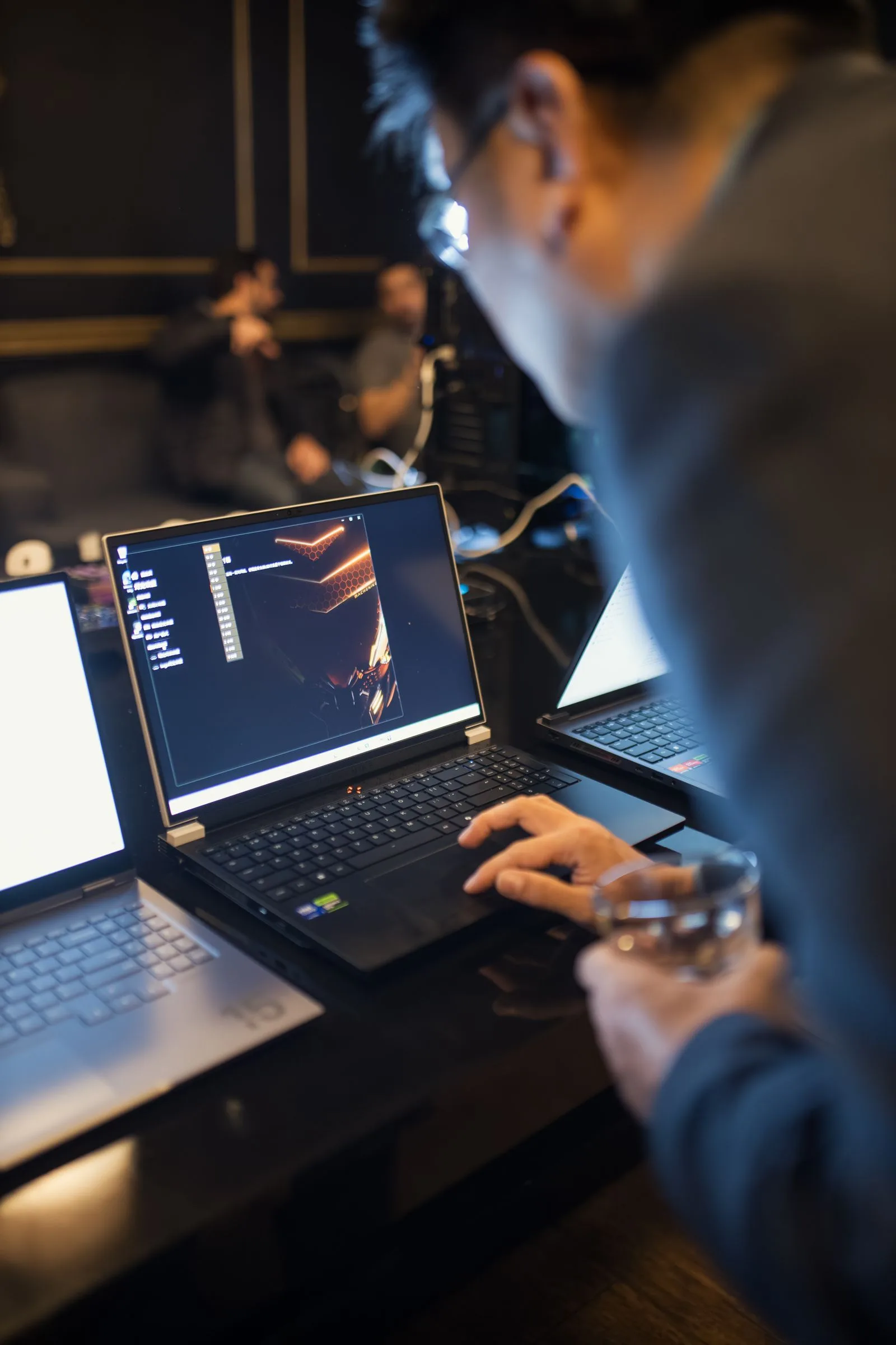 An IT professional working on a laptop in a focused office setting