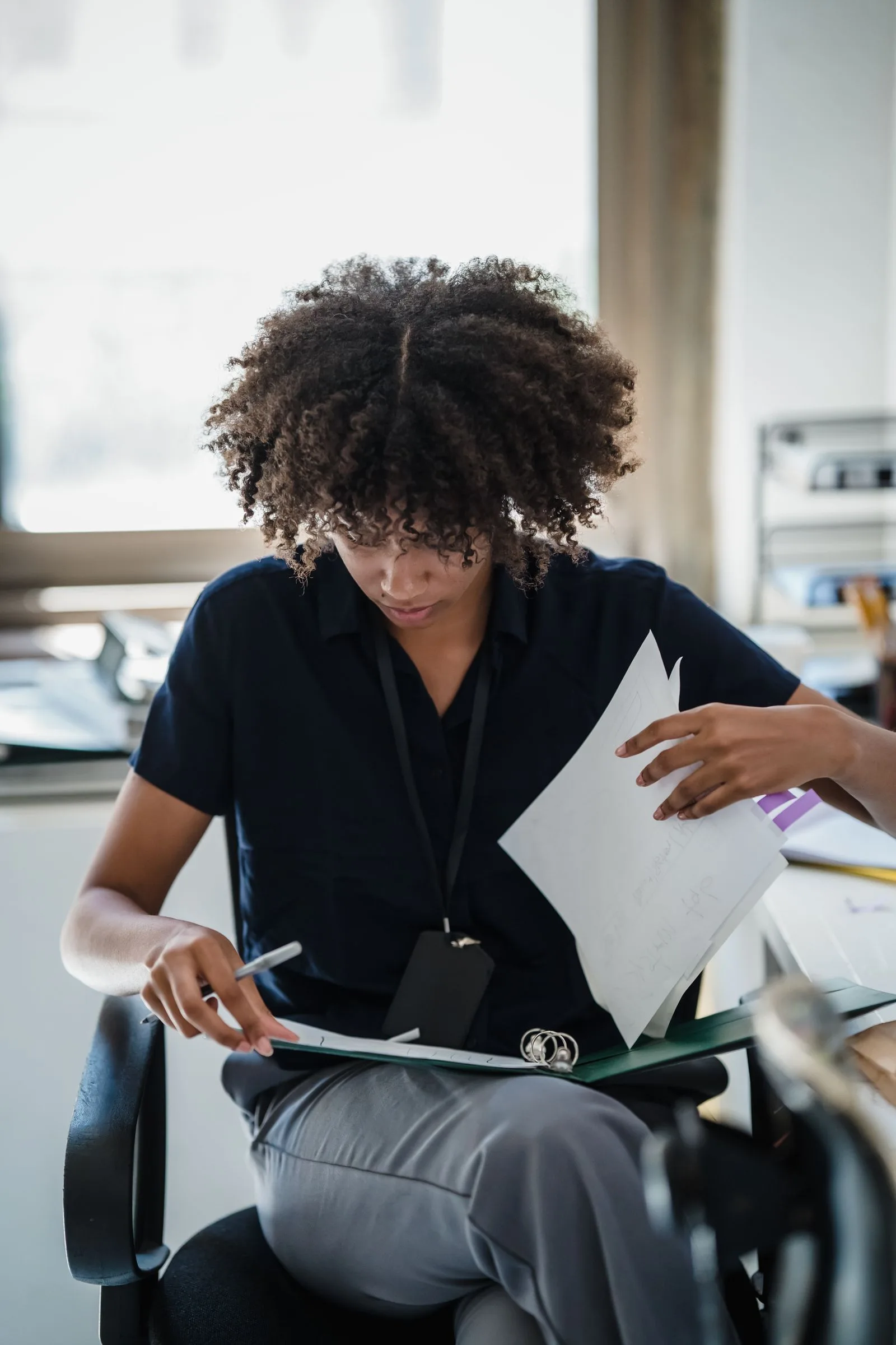 A professional organizing and reviewing office paperwork