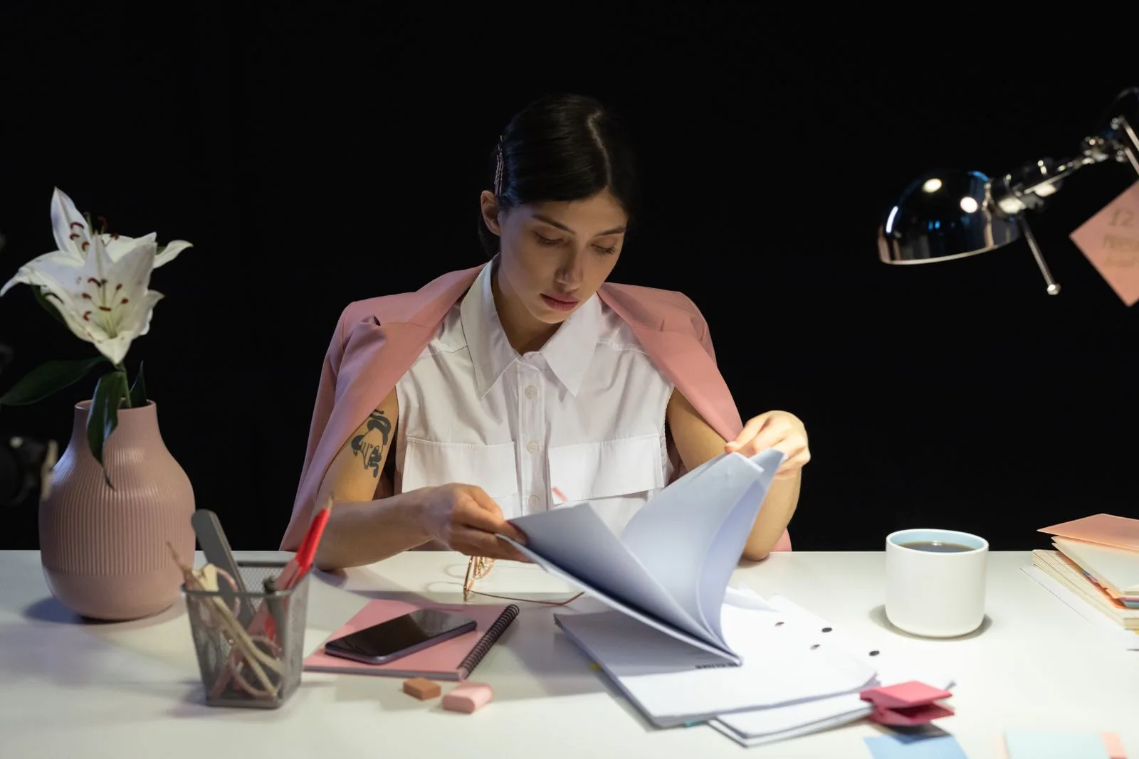 A professional reviewing documents at her desk