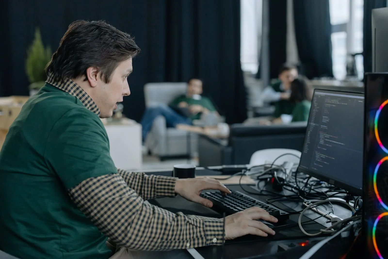 A programmer working at a computer in a contemporary office