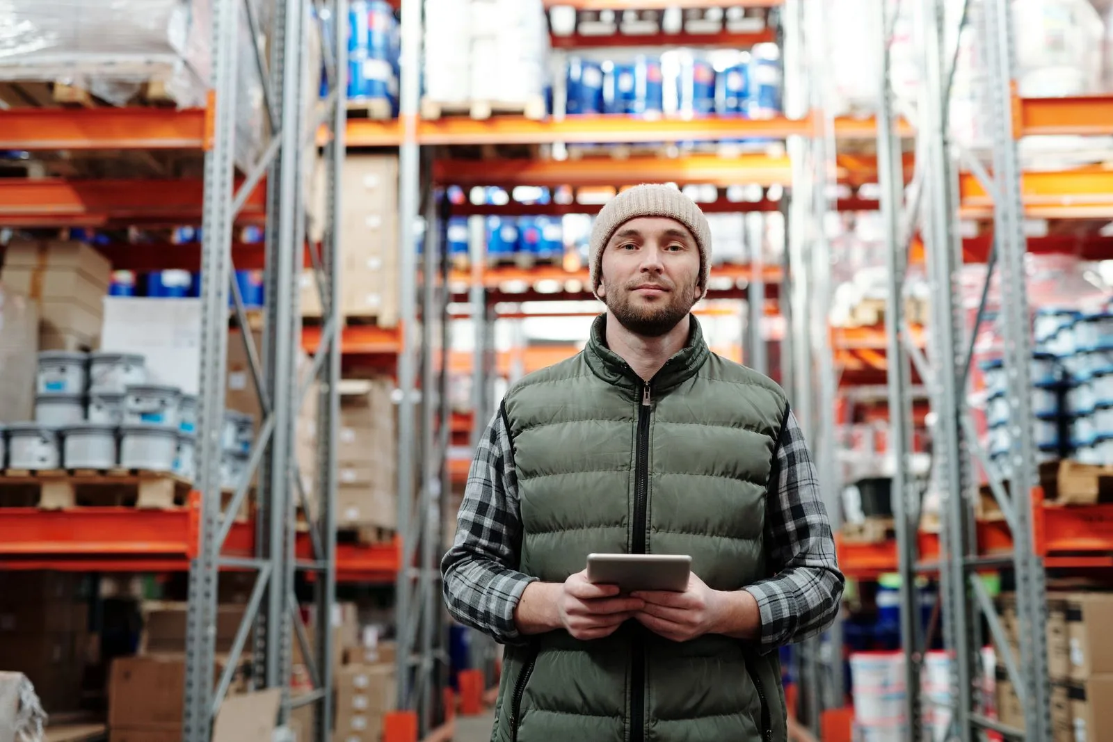 An operations manager using a tablet among warehouse systems